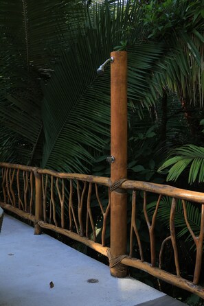 A wooden fence with a metal post and a rope tied around it, set against a backdrop of lush green foliage. - San Pancho Jungle Retreat : Private Pool : Casa Coquitos (San Francisco)