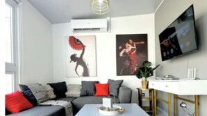 A modern living room with a grey sofa, a coffee table, a TV, and artwork on the wall. - Amazing Views• Pool+Resort Amenities• Private Yard (San Miguel)