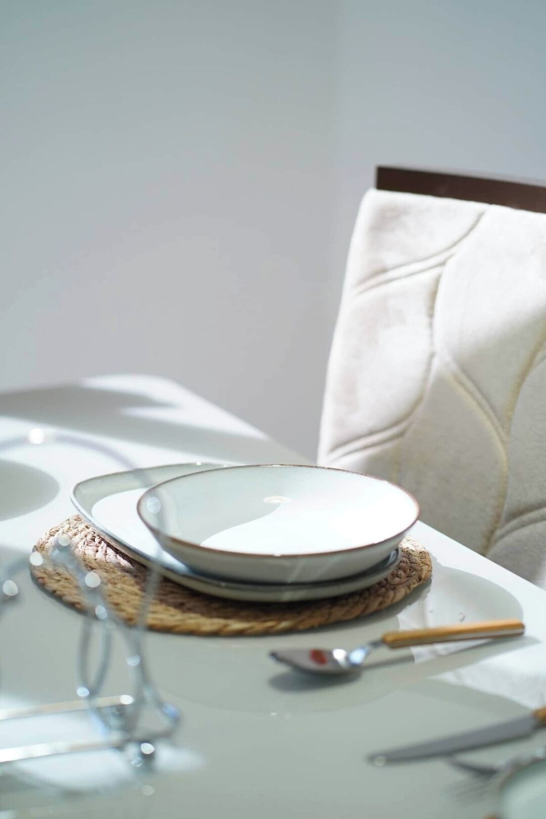 A dining table with plates, a spoon, and a knife.