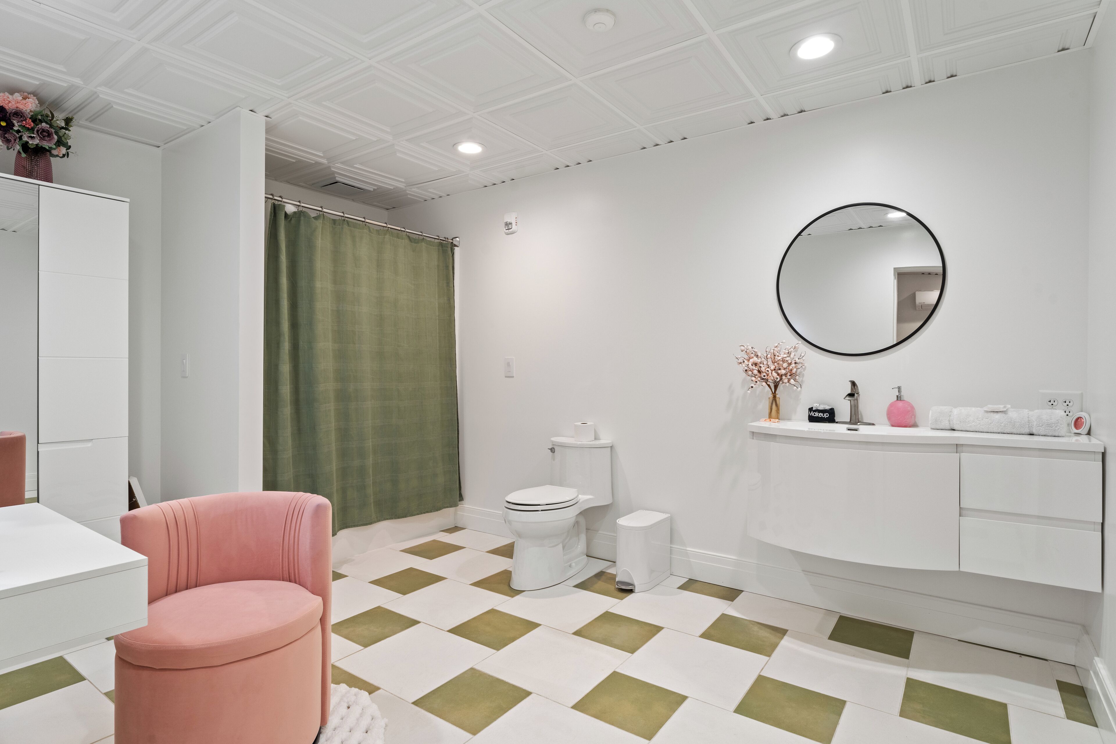 Un baño moderno con inodoro blanco, lavamanos y espejo.