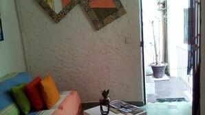 Una sala de estar con un sofá, una mesita y una planta en maceta.