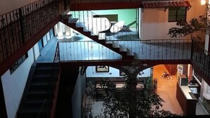 Un edificio de varios niveles con una escalera, un mural y un balcón.