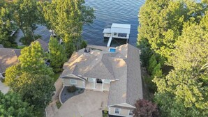 Een woonhuis met een ruime oprit, een garage en een steiger die in het water uitkomt.