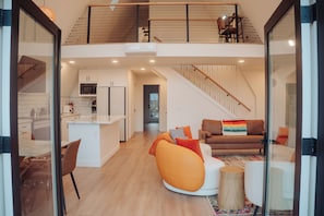 A modern interior with a kitchen, dining area, and living room. - Unique A-Frame house nestled at the edge of rainforest with Sauna & Hot-tub (Forks)
