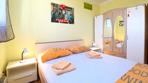 A hotel room with a bed, nightstand, and wardrobe. - Holiday apartment with air conditioning (Pula)