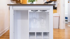A compact kitchen with wooden cabinets, a white countertop, and a built-in wine rack.