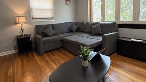 Una sala de estar moderna con un sofá modular, una mesa de centro oscura y una alfombra mullida.