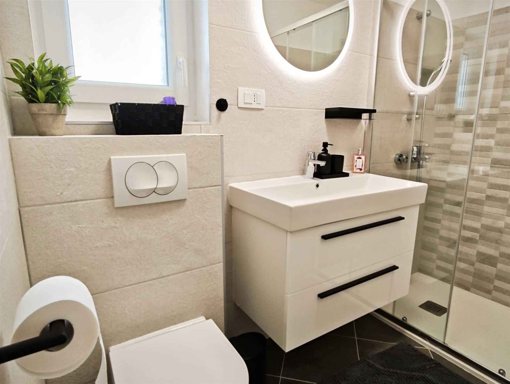 A modern bathroom with a toilet, sink, and shower.