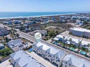 A coastal hotel with multiple buildings, a swimming pool, and a view of the beach. - Rooftop Ocean View + Pool + Golf Cart (Port Aransas)
