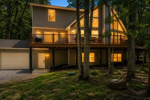 A two-story house with a covered porch, large windows, and a garage. - Mountain View Lodge by PMR, 8BR, Game Room, Hot Tub, Fire Pit, Sleeps 22 (Lake Harmony)