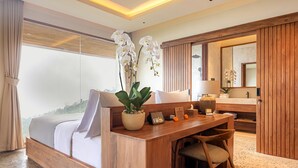 Une chambre d’hôtel moderne avec un grand lit, un bureau en bois, un miroir et une plante en pot.