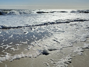 A beach with waves and foam on the sand. - Luxury Shoal Harbor Retreat – Walk to Beach + Pool (Rehoboth Beach)