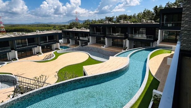 Un hôtel moderne doté d’une grande piscine, de plusieurs bâtiments et offrant une vue dégagée sur le paysage environnant.