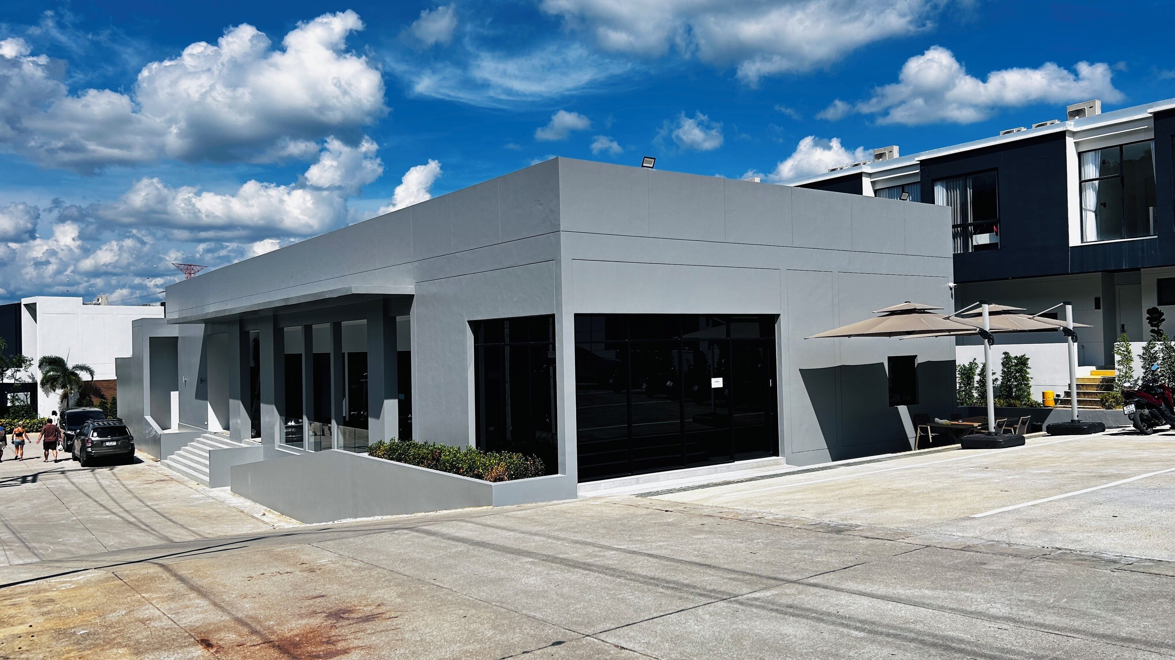 A modern building with large windows and a covered outdoor area.