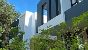 Un bâtiment moderne doté d’un toit plat, de grandes fenêtres et d’une façade blanche.