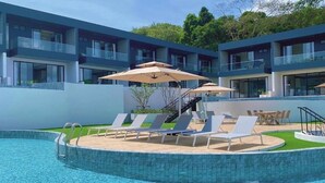Un hôtel moderne doté d’une piscine, de chaises longues et d’un espace extérieur aménagé pour se détendre.