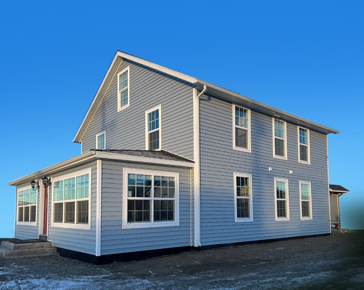 A two-story house with a gabled roof, multiple windows, and a front porch.