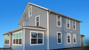A two-story house with a gabled roof, multiple windows, and a front porch.