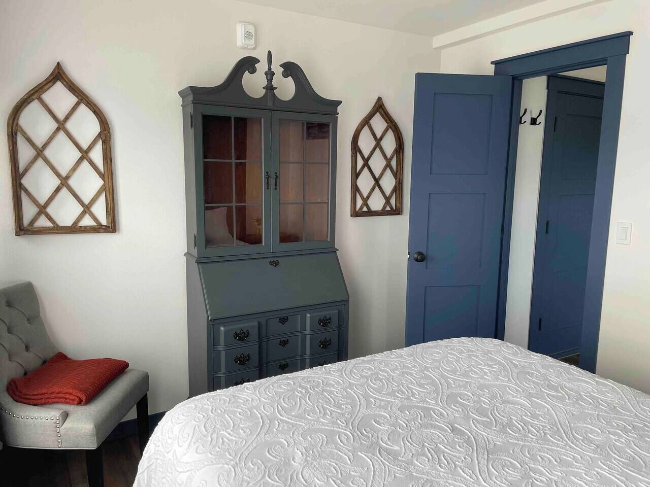 A bedroom with a bed, a dresser, and a wardrobe.