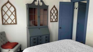 Un dormitorio con cama, cómoda y armario.