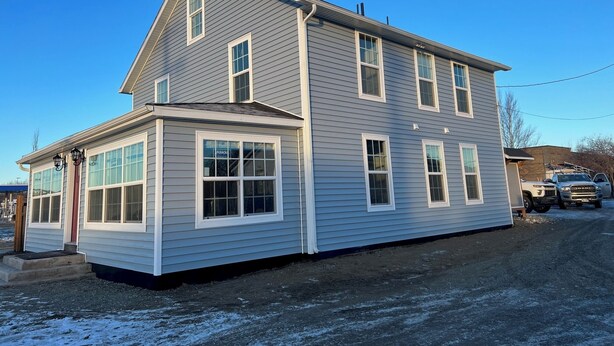 A two-story house with a large front porch and multiple windows. - Van Wormer Room 201, Hyland Hotel (Palmer)