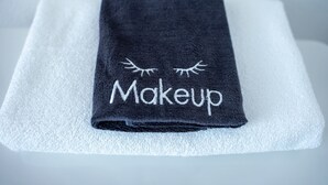 A black towel with the word "Makeup" and an eye design on a white towel. - Bugge Room 203, Hyland Hotel (Palmer)