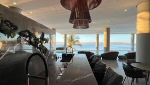 A modern kitchen with a marble countertop, a built-in sink, and a hanging light fixture. - Spacious 3-brdm apartment near charming beach towns: security, bay access & gym (Bucerías)