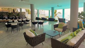 A spacious lounge area with multiple seating options, including sofas and chairs, and a view of the sea. - Spacious 3-brdm apartment near charming beach towns: security, bay access & gym (Bucerías)
