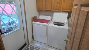 Un cuarto de lavado con gabinetes de madera, lavadora y secadora.