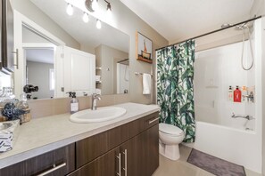 Un baño moderno con un espejo grande, dos lavamanos, un inodoro y una ducha.
