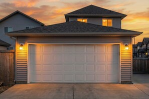 A single-story house with a garage, a sloped roof, and a wooden fence.