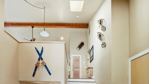 A staircase leading to a second floor, with a wooden bench and a table at the bottom. - Spacious 6-bedroom house in Sunriver perfect for families/groups (Sunriver)