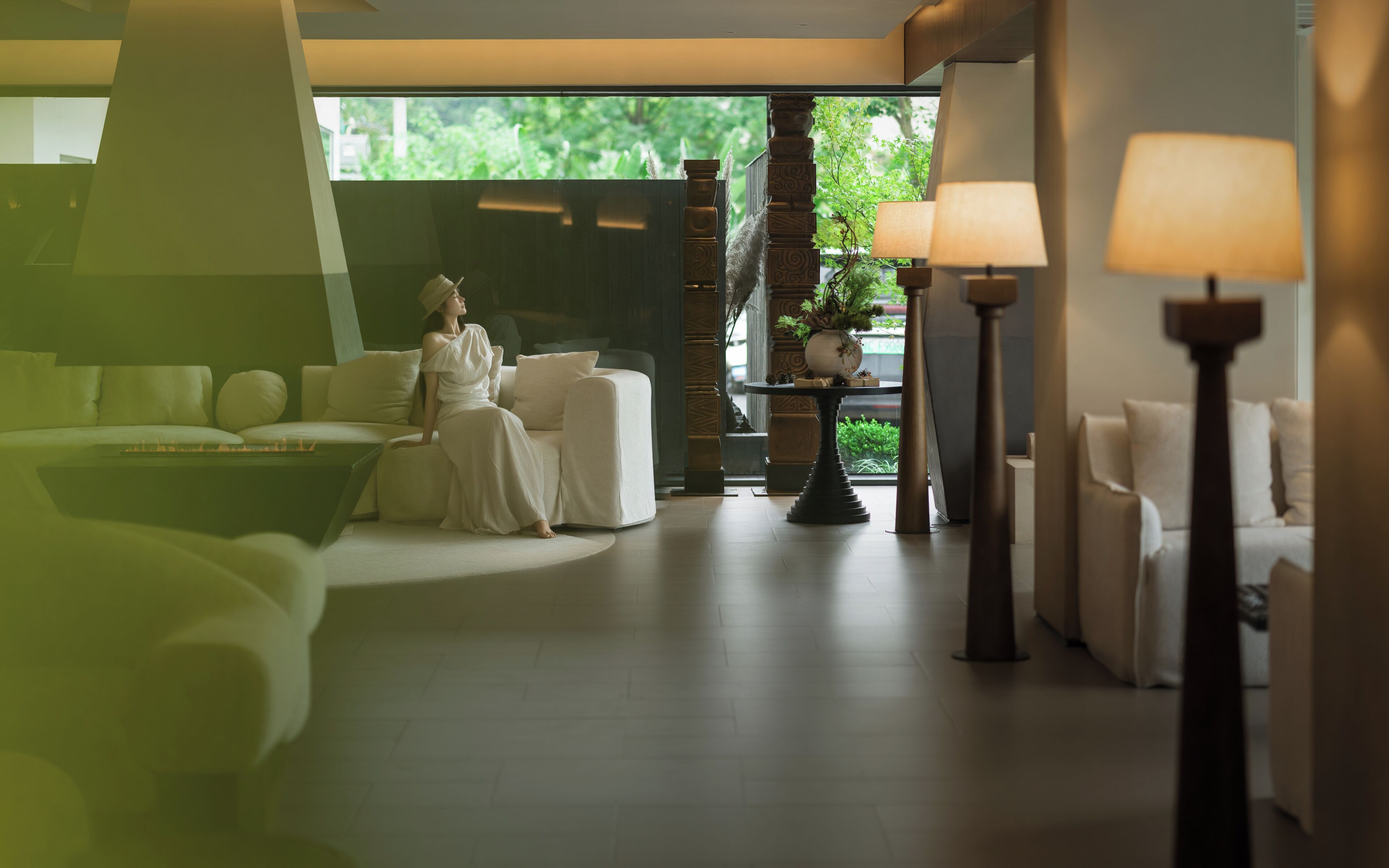 A modern interior with a sofa, a table, and a lamp.