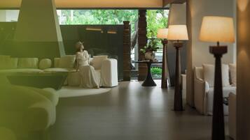 A modern interior with a sofa, a table, and a lamp.
