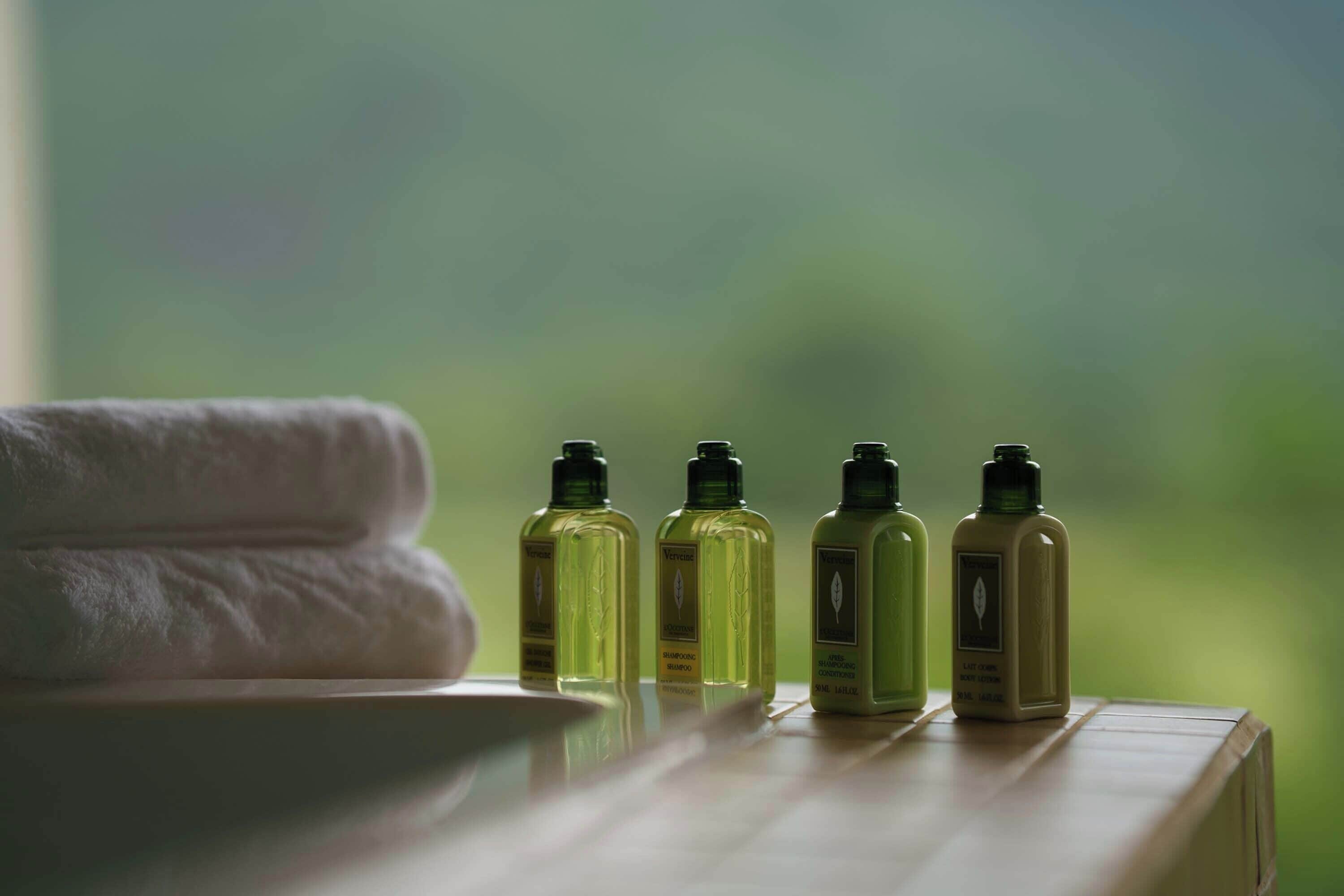 A row of bottles on a wooden surface with a towel in the foreground.