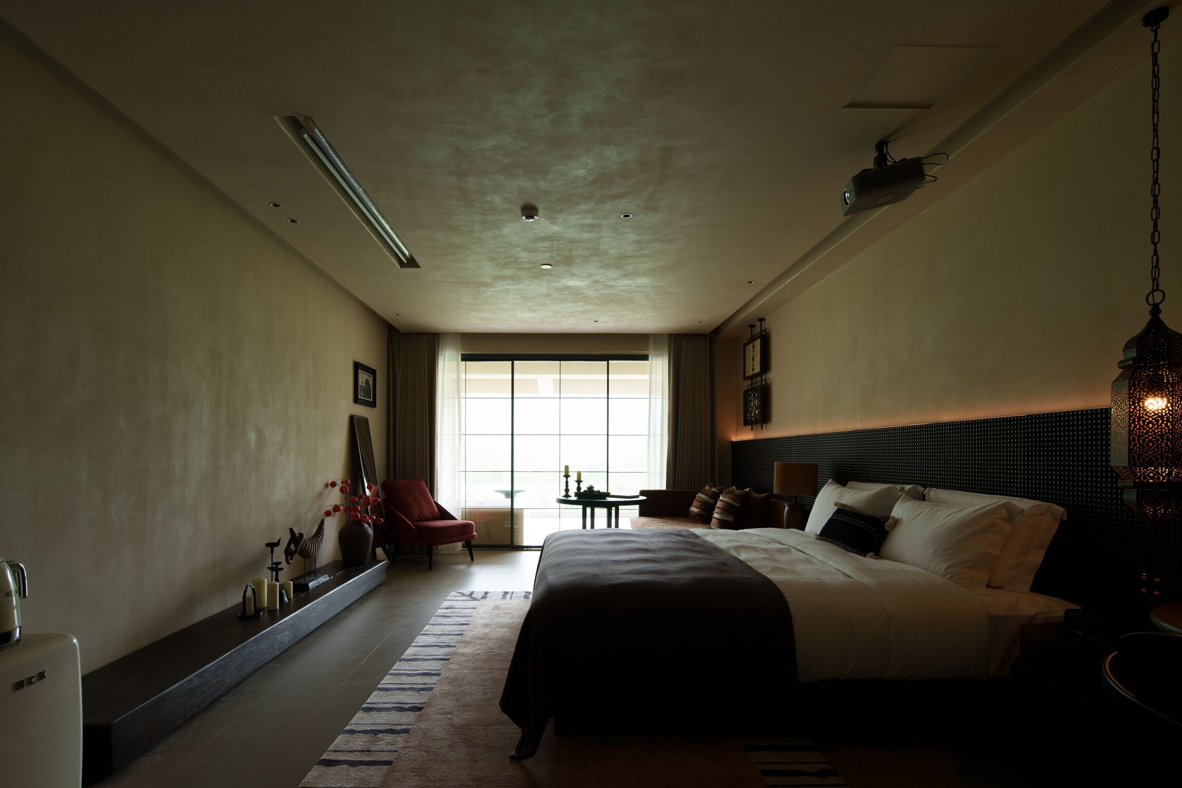Una habitación de hotel con una cama grande, un escritorio, una silla y una ventana con luz natural.