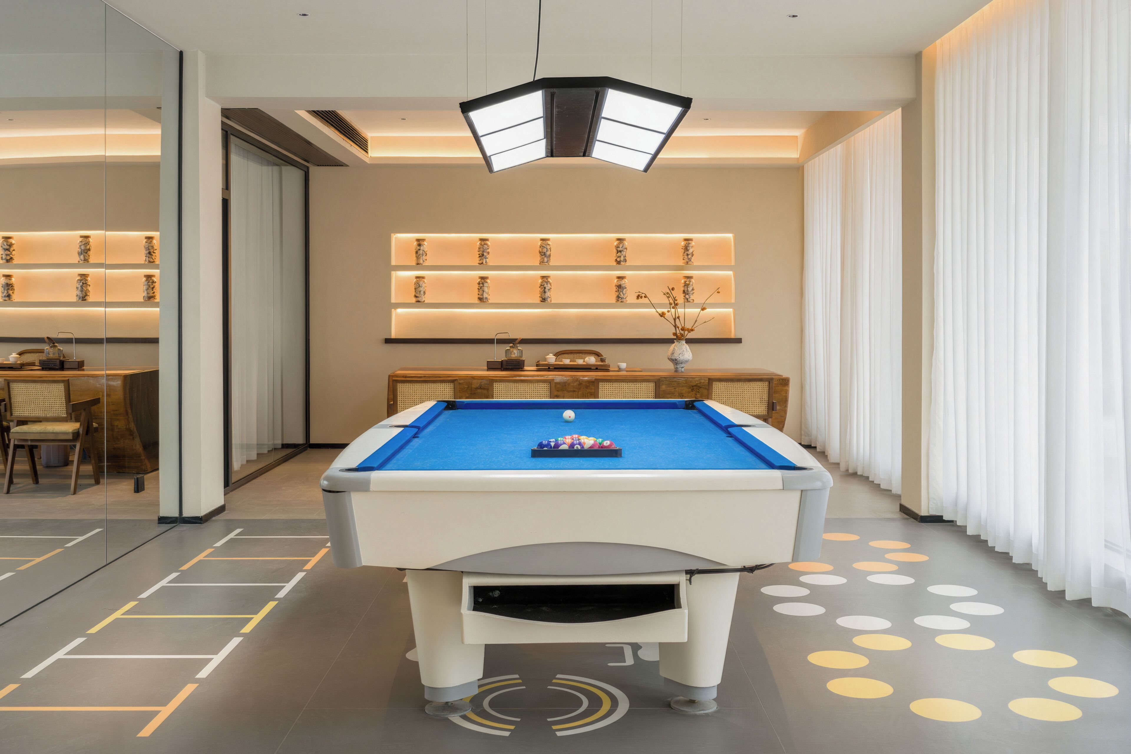 A pool table with a blue felt surface, surrounded by a white table base.