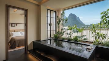 Una habitación de hotel con un ventanal grande, una cama y una fuente de agua.