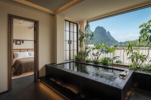 Una habitación de hotel con un ventanal grande, una cama y una fuente de agua.