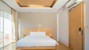 Una camera d'albergo moderna con un letto di legno, un'ampia finestra con tende e una porta in legno.