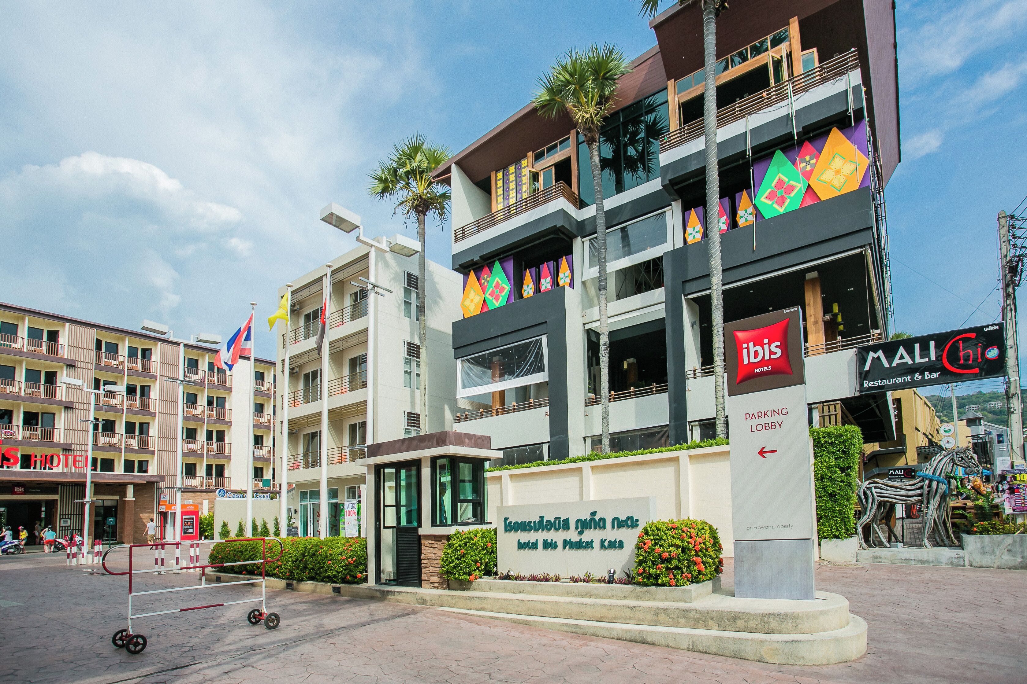 A hotel with multiple floors, balconies, and a parking lobby sign.