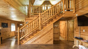 A wooden interior with a staircase, wooden walls, and a television. - Cozy Bear Cabin - Log Cabin Soul, Nashville Heart (Nashville)