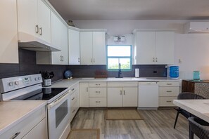 Eine moderne Küche mit weißen Schränken, einem eingebauten Backofen und einem Fenster, das für natürliches Licht sorgt.