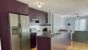 A modern kitchen with a built-in island, stainless steel appliances, and a view to the living area. - Among the Gums, Armagh, Clare Valley (Armagh)