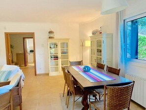 Un comedor con una mesa, sillas y armarios.