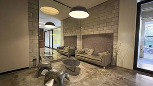 A modern living room with a sofa, coffee table, and unique curved chairs. - Rent Up - Luminoso Duplex en la Boca (Buenos Aires)