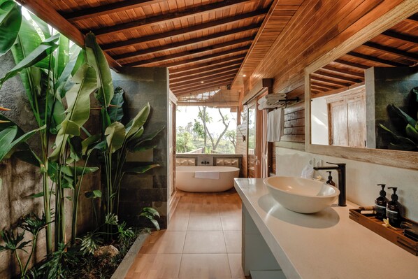 A bathroom with a freestanding bathtub, a large sink, and a wooden ceiling. - Seraya Cove Estate by Manara (Karangasem)