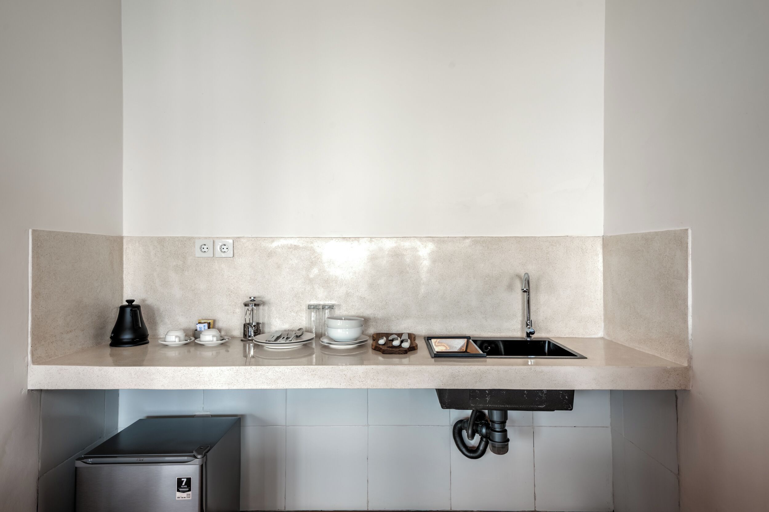 A kitchen with a countertop, sink, and a coffee maker.