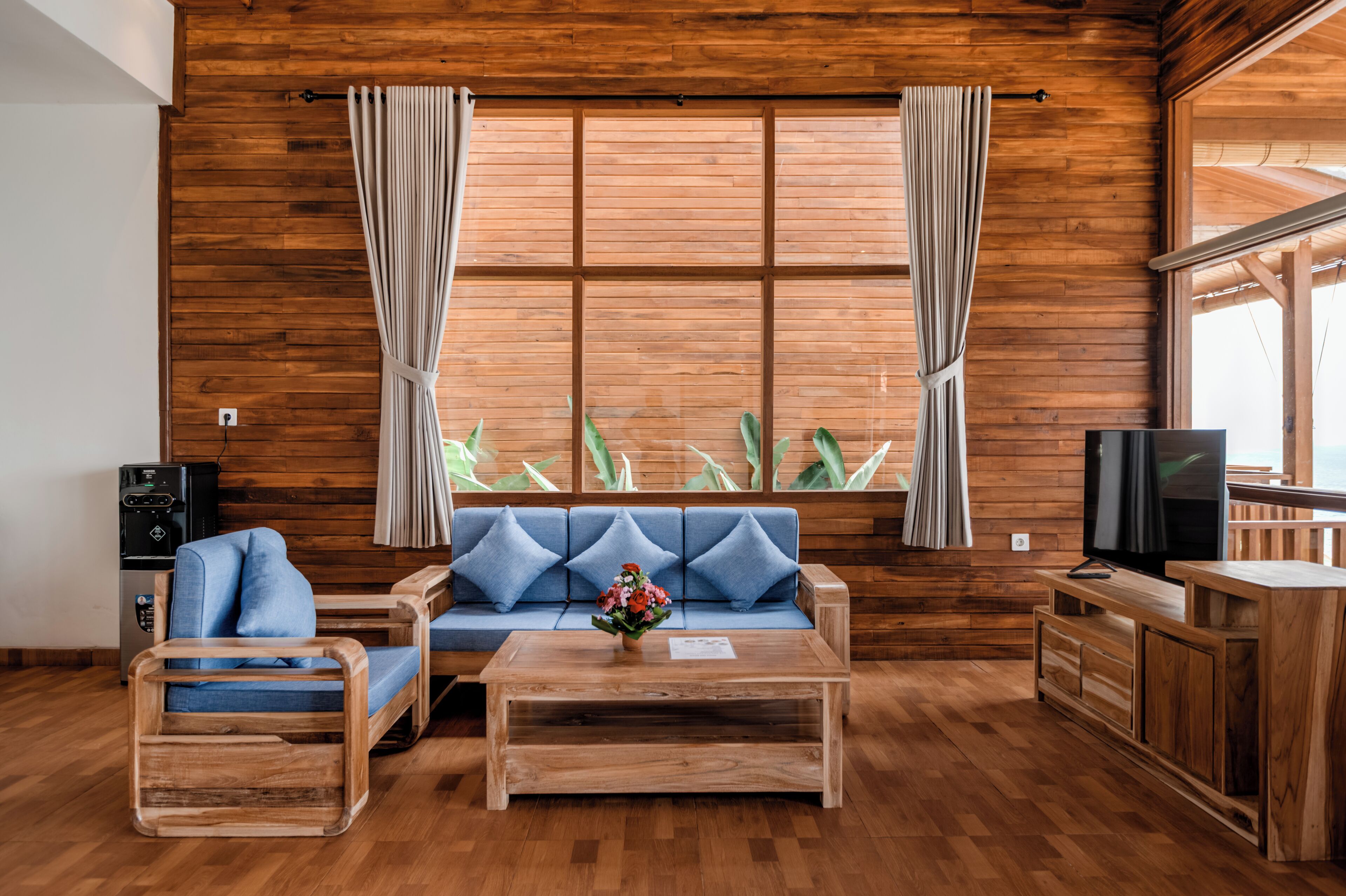 A wooden-paneled room with a sofa, coffee table, and TV stand.