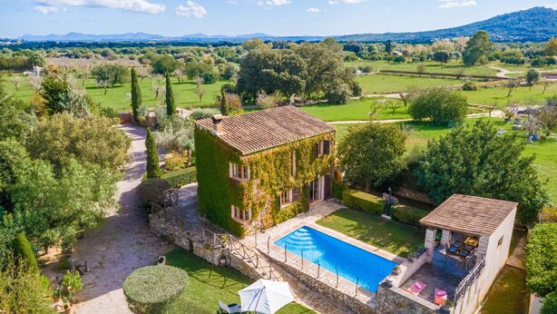Una villa con piscina, immersa nel verde e con vista sul paesaggio collinare.